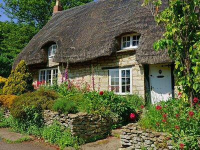 A beautiful quaint Cotswold country Thatched Cottage and garden in summer in the heart of The Cotswolds, Gloucestershire, United Kingdom