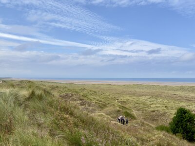 Ramble Worldwide walking group in grassy dunes near beach, Norfolk coast, UK