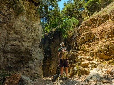 Hiker looking up cliffs in the dried Imbros Gorge, Crete, Greece