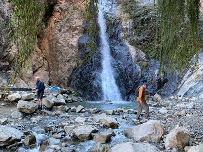 Walkers crossing a waterfall in Morocco