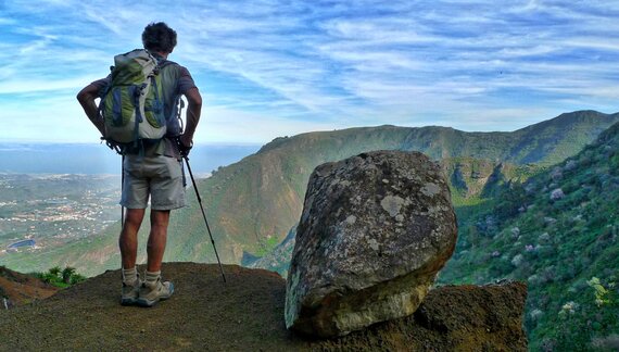 Member of walking holiday group male hiker enjoying view of mountainous landscape in Gran Canaria North Coast, Canary Islands, Spain