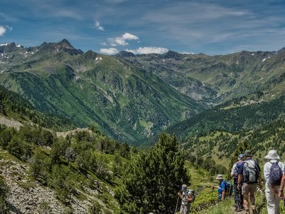 Backshot of hikers Descending from Pic Serrera with expansive view of mountain landscape, Andorra