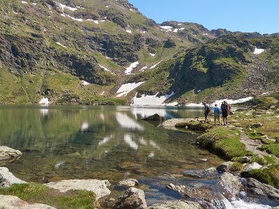 Walking group nearing edge of Tristaina Lakes, Andorra, Europe