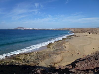 Spanish town playa blanca beach viewed from atop cliff on sunny day, Lanzarote, Spain