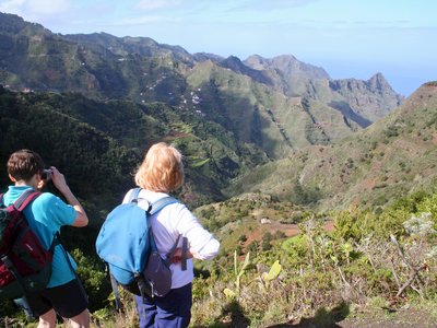 Walker admiring mountainous landscape whilst person takes picture of the stunning view next to them, Tenerife, Spain