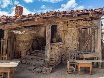 Front view of Wooden and stone taberna shack with small wooden chairs and tables outside, Cantabria, Spain
