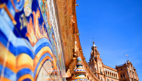 Close up of colourful tile painting on curvature of historic building wall in Plaza de España, Spain square in Seville, Andalucia
