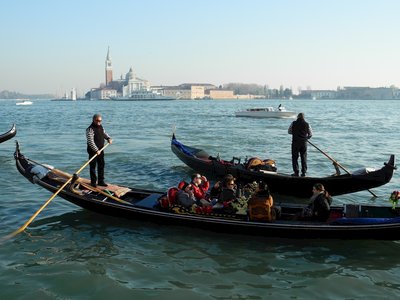  Group of people sat on Gondola with the Church of San Giorgio Maggiore in the distance, Venice, Italy