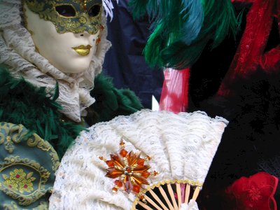 Venice Carnival mask closeup of person holding decorated fan, Italy