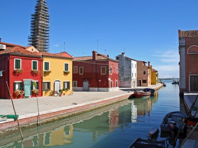 Colourful houses by canal in Burano on sunny day, island in Venice, Italy